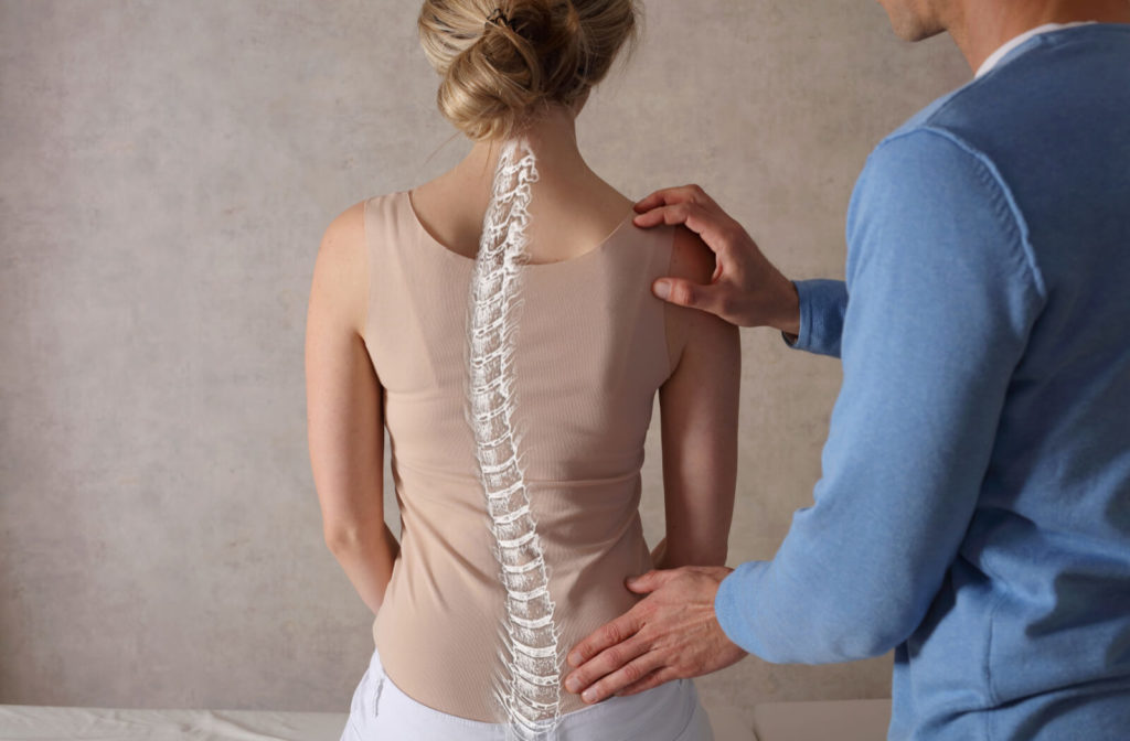 A male chiropractor is doing posture correction with her patient with a curvature spine.