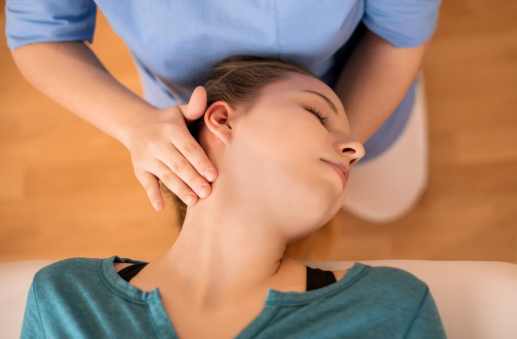 A female chiropractor adjusting a patient's neck.