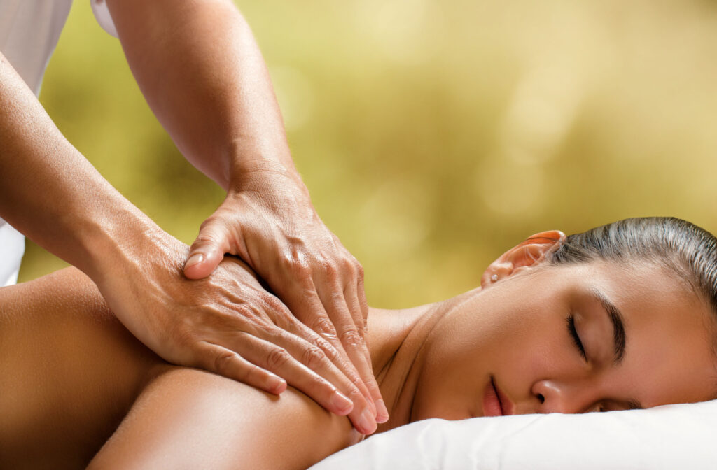 A young woman enjoys the soothing back and shoulder massage.