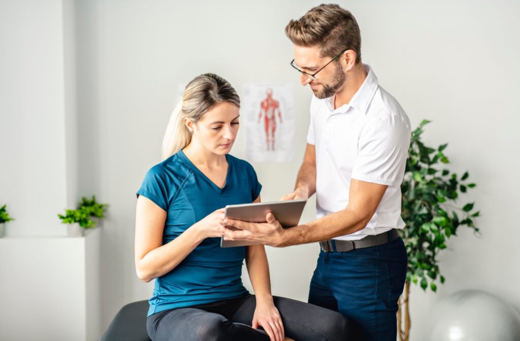 A young woman talks with her physiotherapist about her treatment options.