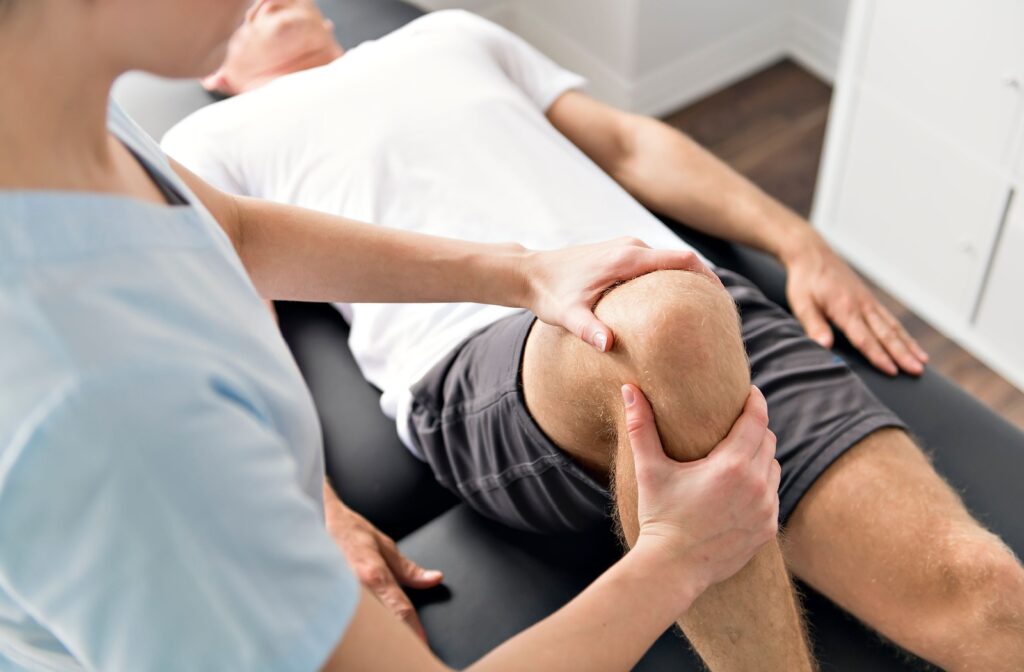 A young man having his knee assessed by a physiotherapist.