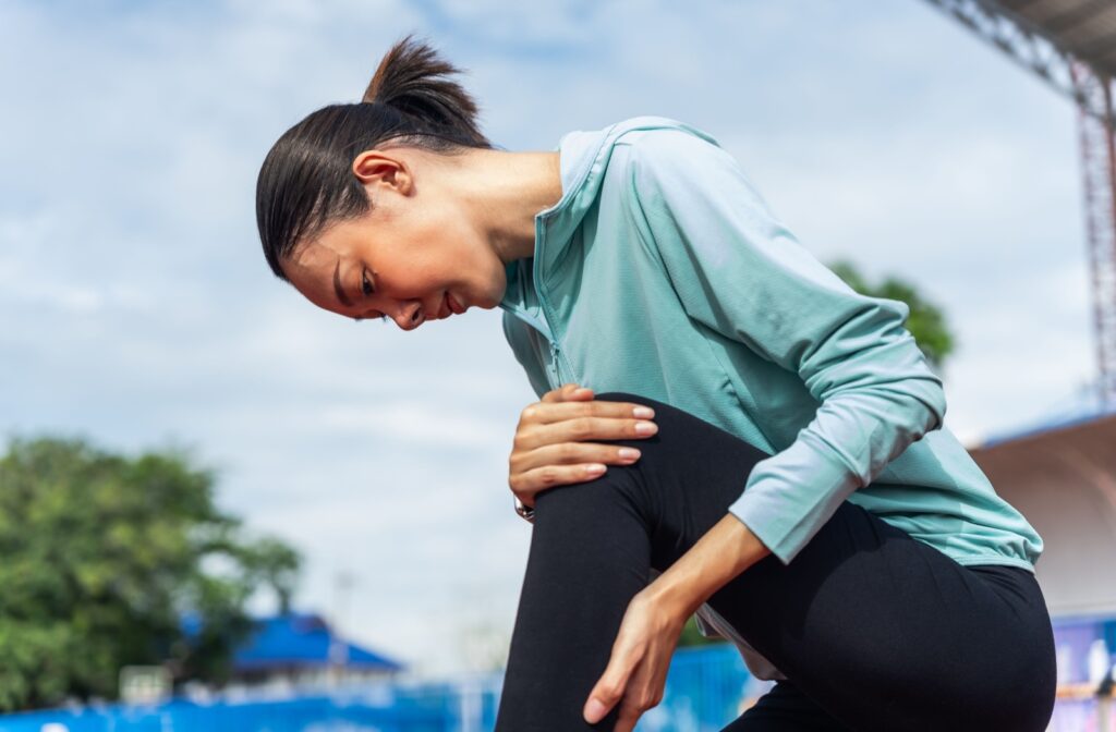 A runner takes a break and massages their leg muscle.