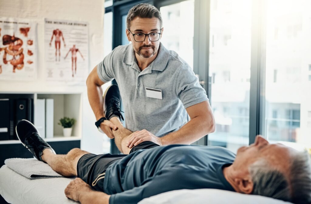 A chiropractor performing an adjustment on a patient's leg while they lay on a chiropractic treatment bed.