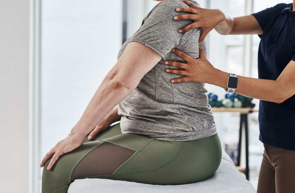 A chiropractor examining a patient's back to learn about where their pain is coming from